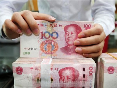 Kiểm tiền mệnh giá 100 Nhân dân tệ tại ngân hàng ở tỉnh Giang Tô, Trung Quốc. Ảnh tư liệu: AFP/TTXVN