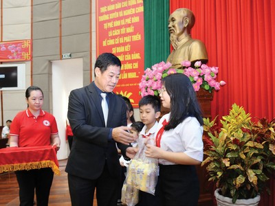 Ông Lâm Bình Vũ trao học bổng và quà cho các em học sinh