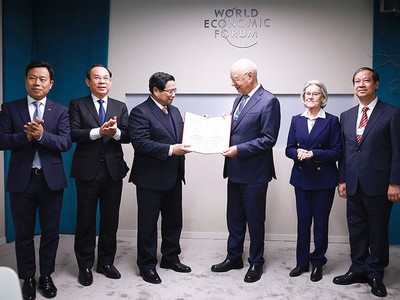 Thủ tướng Phạm Minh Chính trao bằng Tiến sĩ Danh dự của Đại học Quốc gia Hà Nội cho Giáo sư Klaus Schwab. Ảnh: Nhật Bắc 