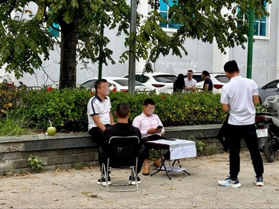 Các đội nhóm ngang nhiên rao bán chênh ngay trước nơi tổ chức phiên đấu giá đất. Ảnh: Thanh Vũ