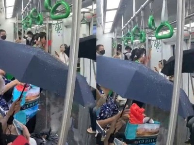 Hành khách che ô khi đi tàu metro Cát Linh - Hà Đông.
