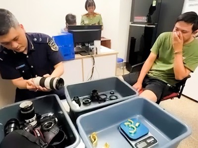 Đối tượng (bên phải) tại cơ quan chức năng.