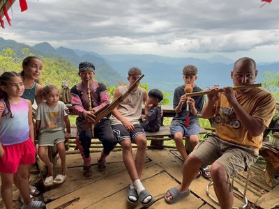 Giàng A La hướng dẫn du khách nước ngoài sử dụng nhạc cụ truyền thống của đồng bào Mông.