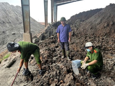 Lực lượng chức năng kiểm tra khu vực chôn lấp chất thải. Ảnh: BCA