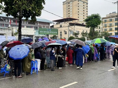 Người dân "đội mưa" xếp hàng nộp hồ sơ mua nhà ở xã hội.