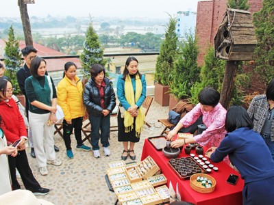Đại biểu trải nghiệm tour “Đánh thức” tại xã Vân Đình, nghe giới thiệu về trà Trấn Thị. Ảnh: TITC