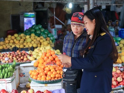 Công chức thuế hỗ trợ hộ kinh doanh thực hiện các thủ tục về thuế. Ảnh: Đức Thanh.