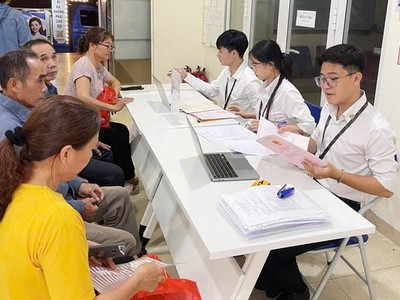 Cán bộ của Trung tâm phục vụ hành chính công Hà Nội hướng dẫn thủ tục cho người dân. Ảnh minh họa.