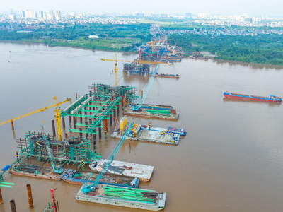 Toàn cảnh công trường Cầu Trần Hưng Đạo, nhiều mũi thi công đang được triển khai đồng loạt trên bờ và giữa sông Hồng.