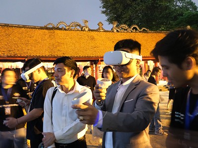 Du khách trải nghiệm công nghệ thực tế ảo tại Văn Miếu - Quốc Tử Giám. Ảnh: Hạnh Phúc.