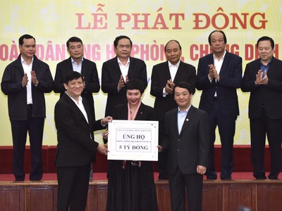 Bà Lương Lan My, Giám đốc truyền thông SSI (giữa) trao tặng 5 tỷ đồng tại Lễ Phát động toàn dân ủng hộ phòng, chống Covid-19 sáng 17/3