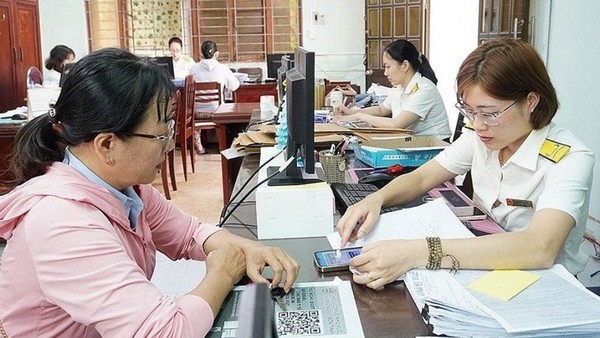 Cán bộ Thuế hướng dẫn người nộp thuế thực hiện thủ tục. (Ảnh tư liệu)