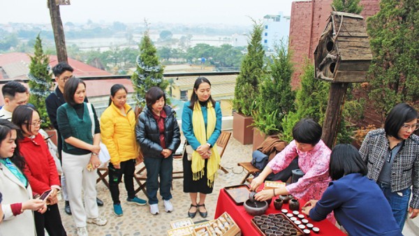 Đại biểu trải nghiệm tour “Đánh thức” tại xã Vân Đình, nghe giới thiệu về trà Trấn Thị. Ảnh: TITC