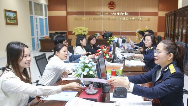 Công chức Thuế tỉnh Thái Nguyên hỗ trợ người nộp thuế thực hiện pháp luật thuế. Ảnh: Đức Thanh