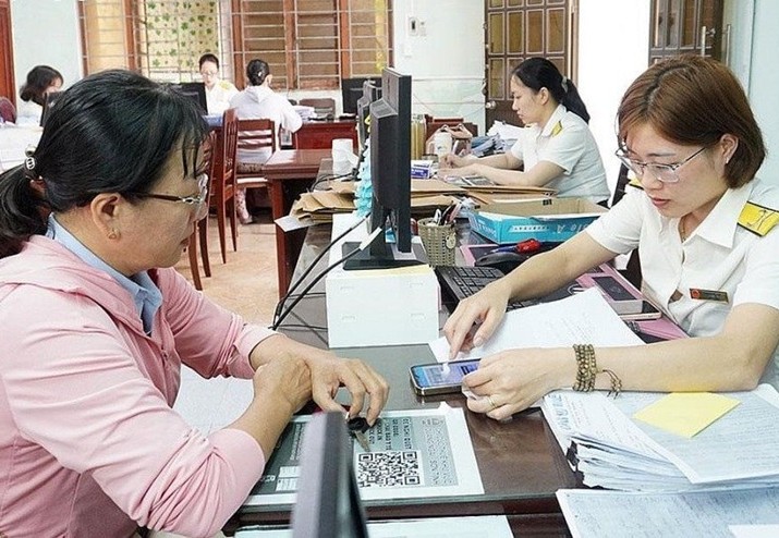 Cán bộ Thuế hướng dẫn người nộp thuế thực hiện thủ tục. (Ảnh tư liệu)