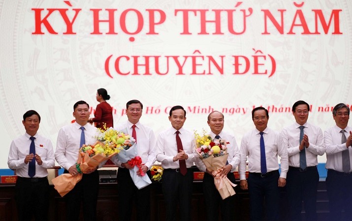 Bí thư Thành ủy TP.HCM Trần Lưu Quang tặng hoa chúc mừng 3 tân Phó chủ tịch UBND TP.HCM - Ảnh: H.K