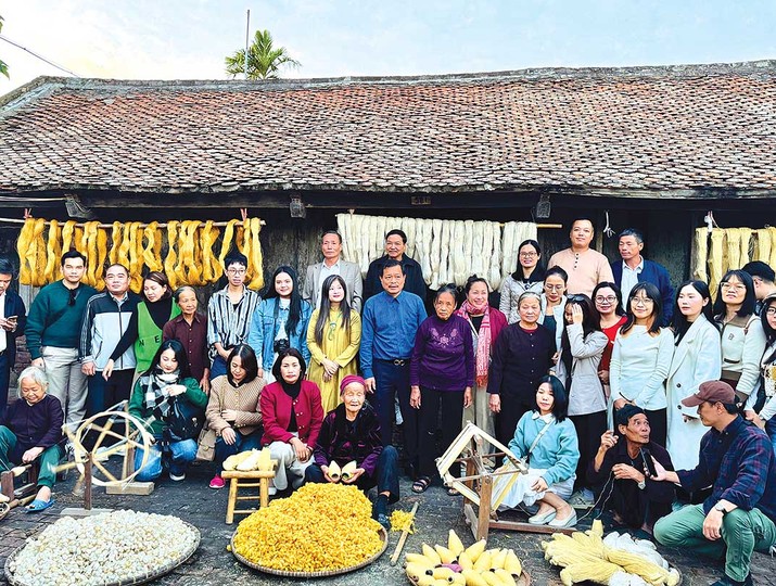 Các nghệ nhân trình diễn và hướng dẫn du khách trải nghiệm se tơ, rút đũi tại làng nghề dệt đũi Nam Cao (Ảnh: Hồ Hạ) 