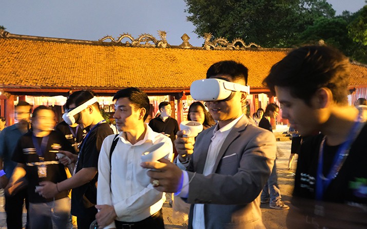 Du khách trải nghiệm công nghệ thực tế ảo tại Văn Miếu - Quốc Tử Giám. Ảnh: Hạnh Phúc.
