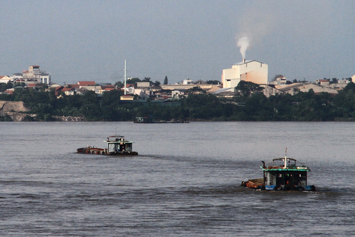 Các tàu chở đầy cát nhìn như sắp chìm đi trên sông.