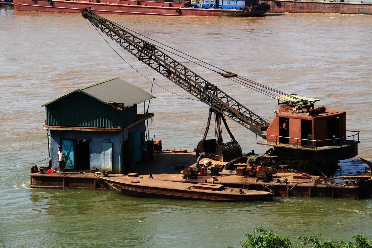 Một chiếc tàu múc cát đậu ngay bờ sông.