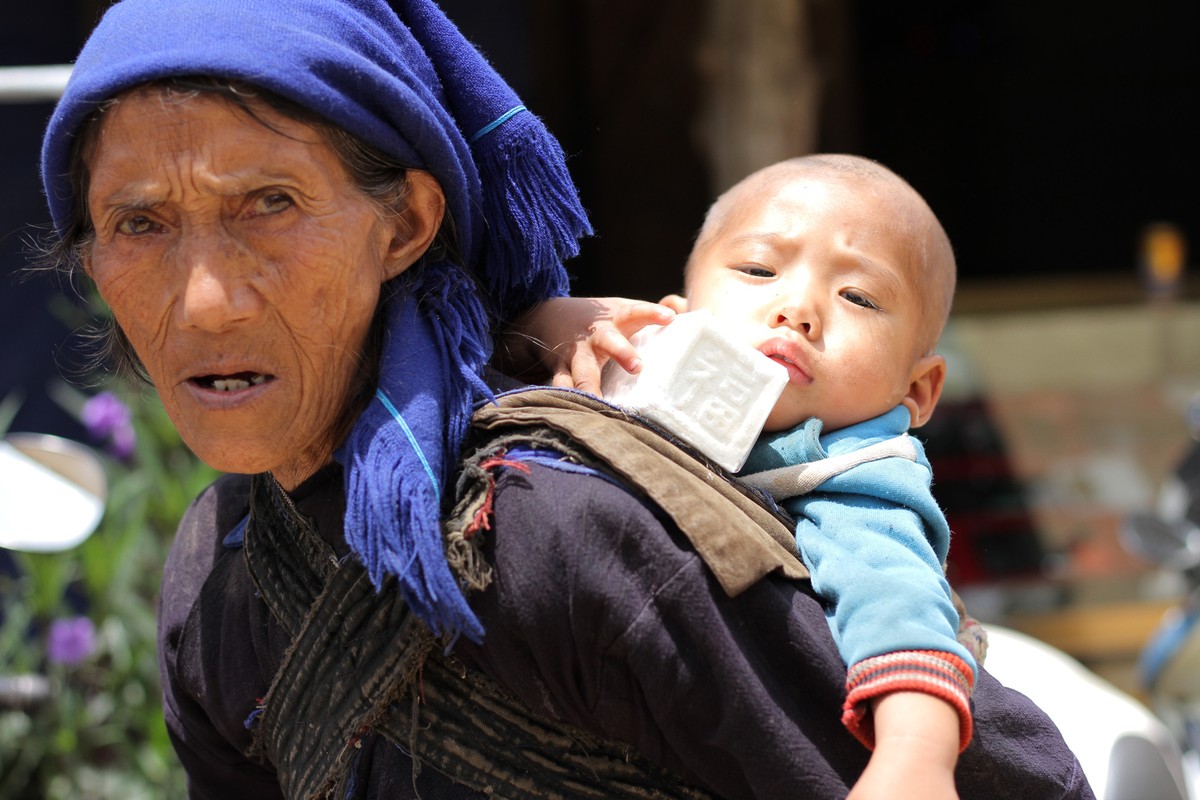 Các em bé thường sẽ được &quot;địu&quot; trên lưng. Ảnh: Thành Nguyễn.