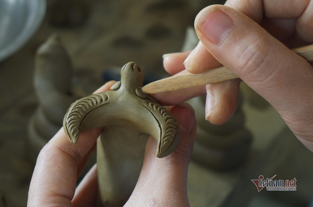 Nghệ nhân ở làng gốm Thanh Hà nặn tượng trâu đất.
