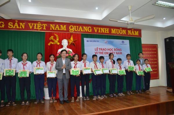 Ông Võ Đình Tiến, giám đốc Sở Kế hoạch và Đầu tư tỉnh Phú Yên và ông Bùi Đức Hải (bìa phải)- Phó Tổng biên tập thường trực Báo Đầu tư trao học bổng và chúc mừng các em học sinh.