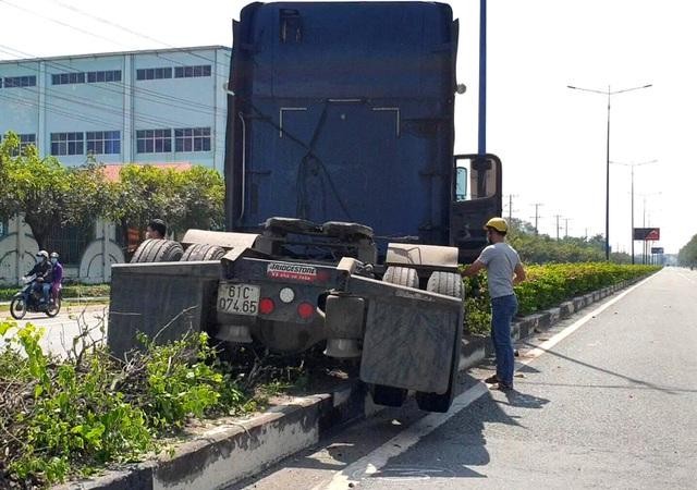Xe đầu kéo lao lên dải phân cách sau khi tông trúng xe du lịch.