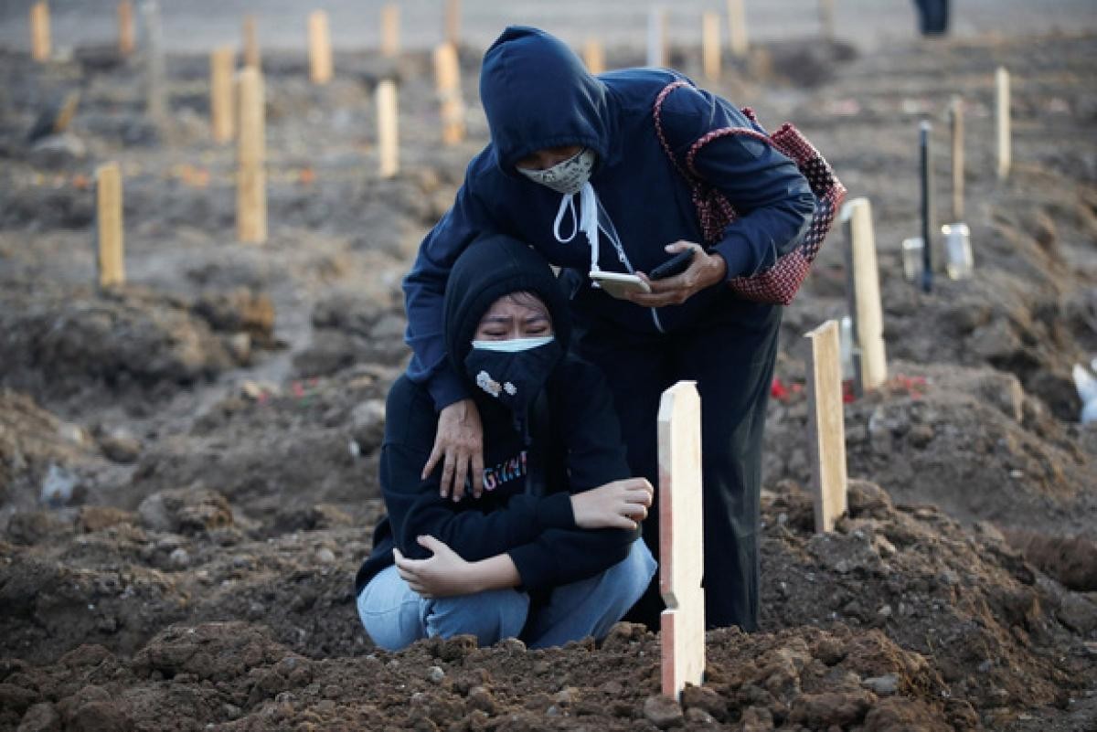 Một phụ nữ Indonesia khóc nấc bên nấm mộ sơ sài của người thân qua đời vì Covid-19 ngày 28/6. Ảnh: Reuters.