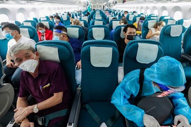 Hành khách trên chuyến bay của Vietnam Airlines thực hiện ngồi giãn cách ghế theo đúng quy định. (Ảnh: CTV/Vietnam+).