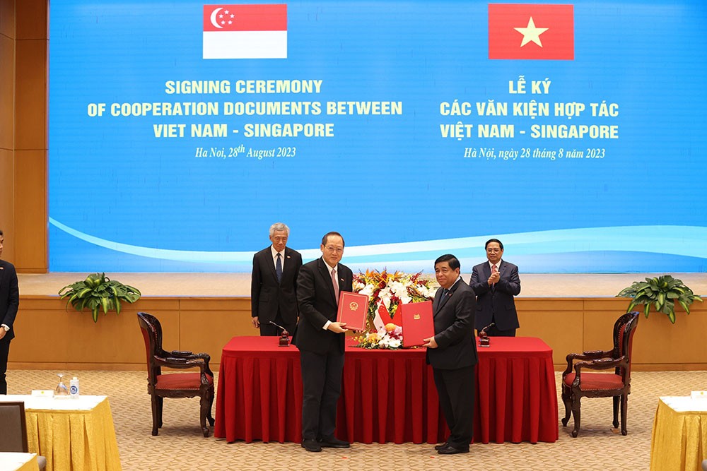 Bộ trưởng Bộ Kế hoạch và Đầu tư Nguyễn Chí Dũng và Bộ trưởng Bộ Nhân lực kiêm Bộ trưởng thứ hai Bộ Công thương Singapore Tan See Leng ký Công thư trao đổi về việc sửa đổi Hiệp định Khung kết nối hai nền kinh tế Việt Nam - Singapore (Ảnh: Đức Thanh).