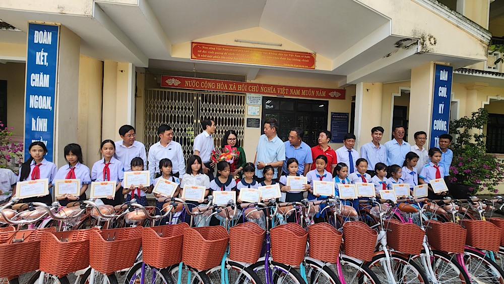 Các em học sinh nhận phần quà học bổng xe đạp.