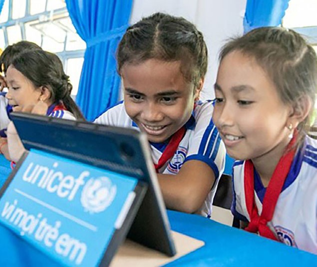 Như (trái) và các bạn lần đầu trải nghiệm thư viện số trên máy tính bảng.