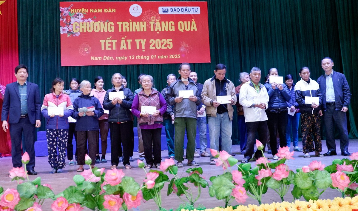 Ông Văn Đức Hiệp (hàng trên ngoài cùng bên phải), Kế toán trưởng Báo Đầu tư và ông Phạm Văn Ái, Ủy viên Ban thường vụ Huyện ủy, Phó Chủ tịch HĐND huyện Nam Đàn (ngoài cùng bên trái) trao quà tết cho bà con