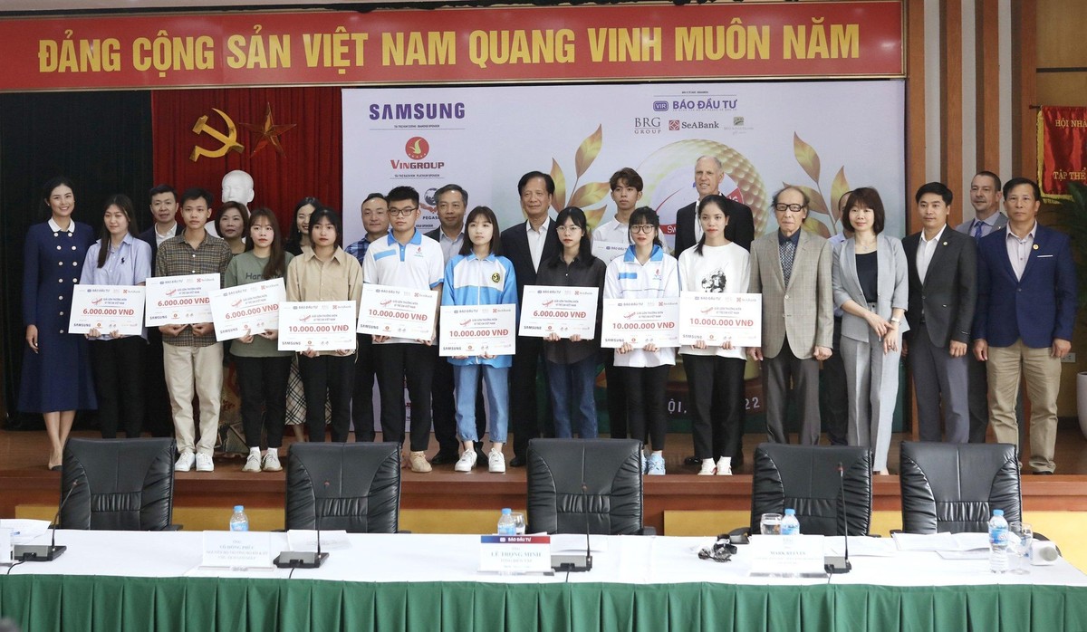 Đại diện ban tổ chức và khách mời chụp ảnh lưu niệm cùng các em học sinh được nhận học bổng