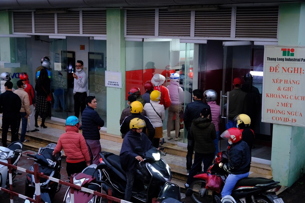 Công nhân, người lao động tại các khu công nghiệp trên địa bàn TP. Hà Nội (Thăng Long, Nội Bài...) phải chờ đợi hàng dài dưới mưa trong ngày 28 Tết để chờ đợi rút tiền từ cây ATM.