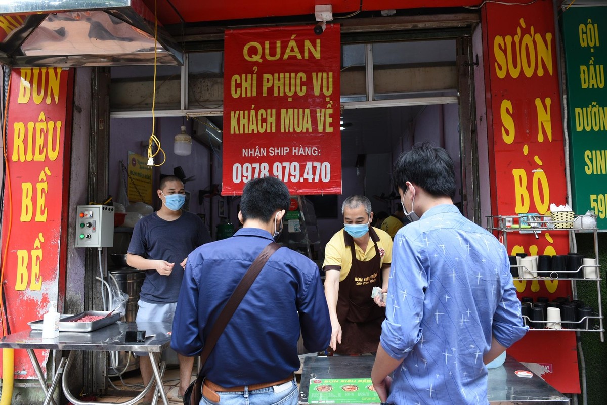 Đúng 12h trưa, các cửa hàng đồng loạt mở cửa đón khách. Cửa hàng bán bún trên đường Cốm Vòng đưa thực đơn ra ngoài cửa để khách đến không phải vào trong cửa hàng vẫn dễ dàng chọn món.