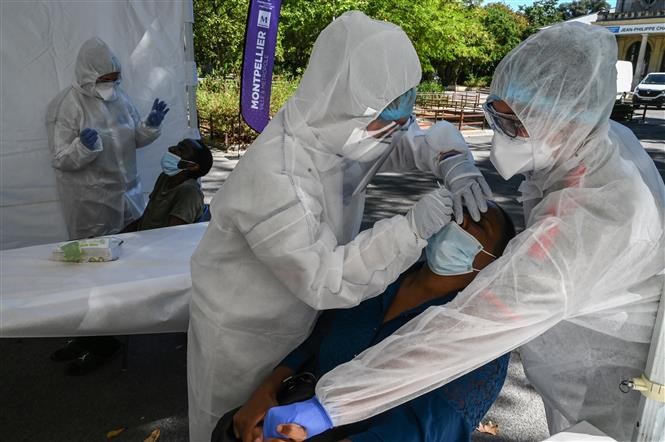 Nhân viên y tế lấy mẫu dịch xét nghiệm COVID-19 cho người dân tại Montpellier, Pháp, ngày 3/9/2020. Ảnh: AFP/ TTXVN