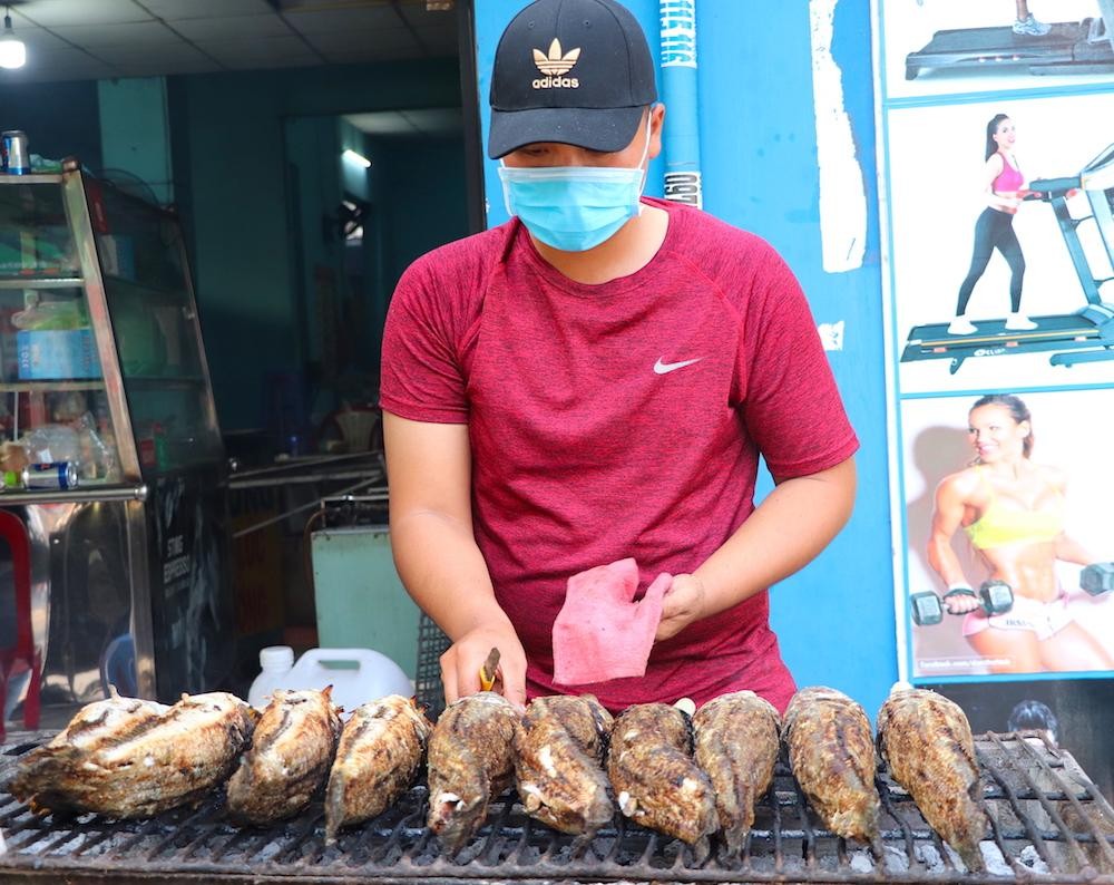 Người nướng cá phải liên tục xoay trở, cạo lớp vảy khét bên ngoài cũng như quét thêm lớp dầu bên ngoài cá (Ảnh: T. Hồng).