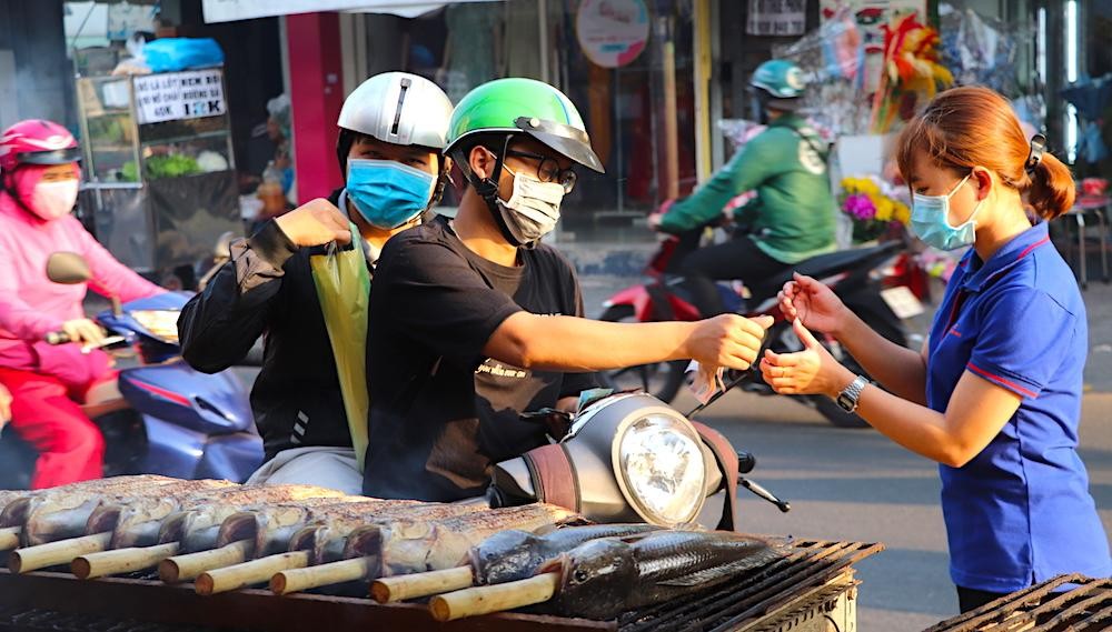 Khách hàng mua cá lóc nướng trước ngày vía Thần Tài (Ảnh: T.Hồng).