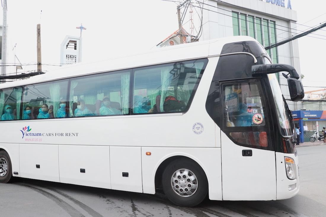 Xe chở các ca nhiễm Covid-19 đi ra từ đường Bùi Văn Ba, vào chiều 12.7 (Ảnh: Thị Hồng).