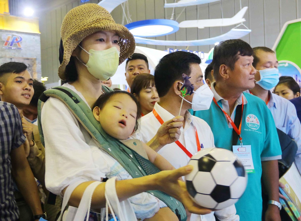 Một em bé người nước ngoài ngủ say trong vòng tay mẹ, còn mẹ thì vẫn mải mê trải nghiệm các cảnh đẹp của Việt Nam tại triển lãm. Một em bé người nước ngoài ngủ say trong vòng tay mẹ, còn mẹ thì vẫn mải mê trải nghiệm các cảnh đẹp của Việt Nam tại triển lãm.