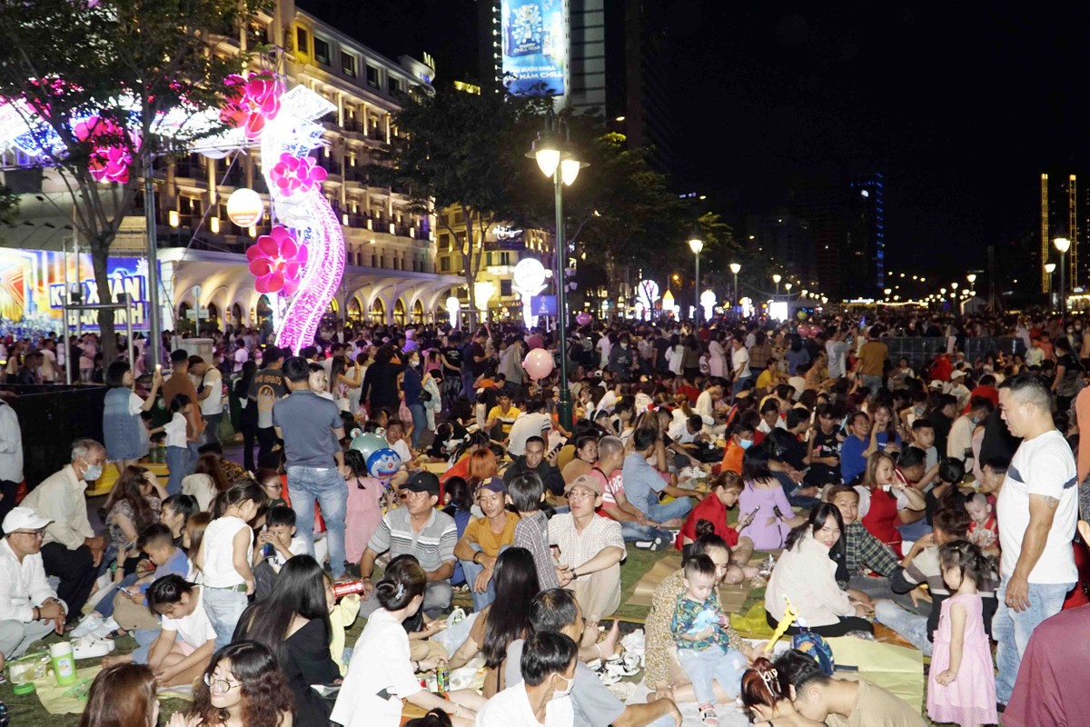 Khoảng 21 giờ tối, hàng nghìn người đã có mặt, chọn chỗ ngồi trước trong công viên Bạch Đằng, Quận 1 để chờ ngắm pháo hoa.