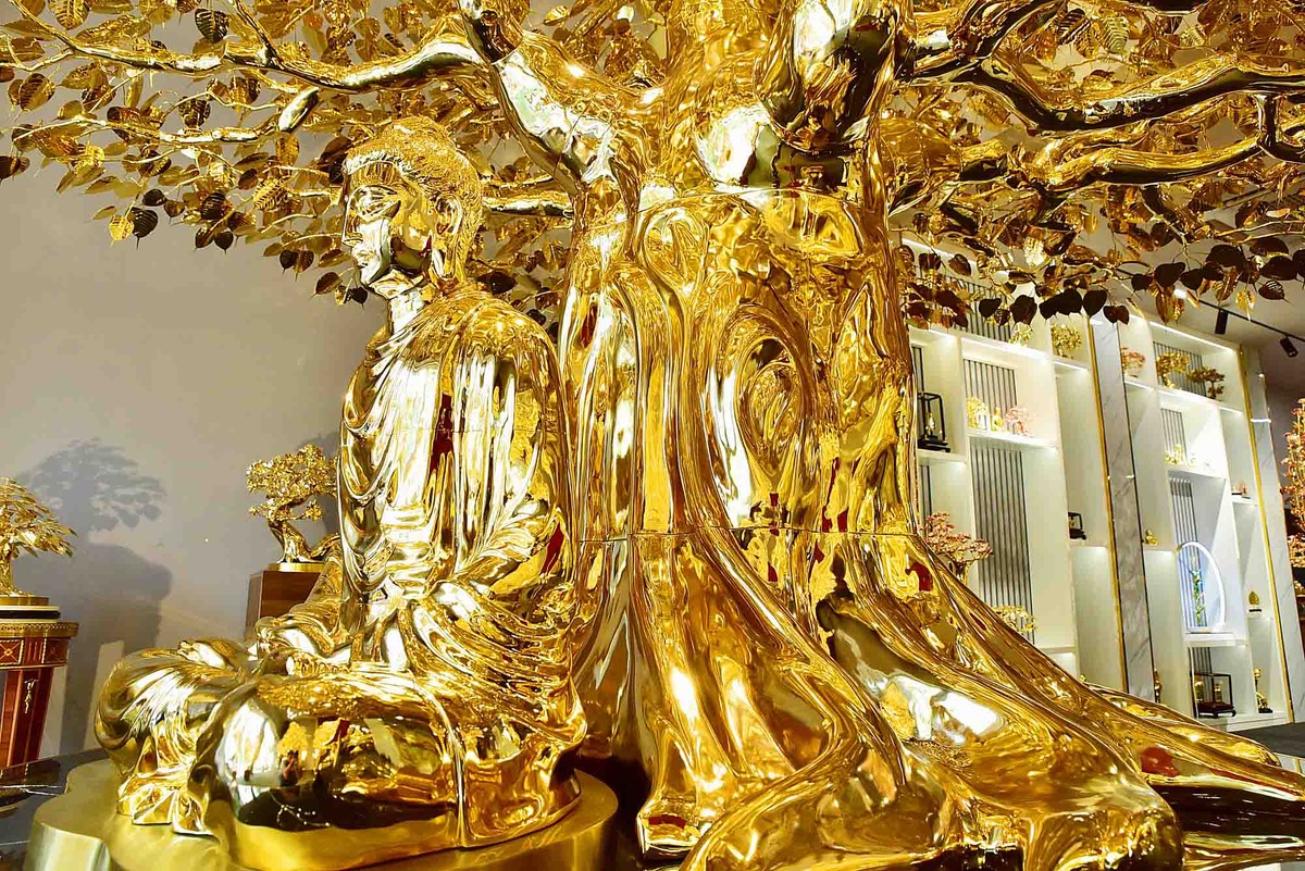 Phần thân cây được ghép từ các khối, bên cạnh gốc cây là tượng Phật cao hơn 1m. Phần thân cây được ghép từ các khối, bên cạnh gốc cây là tượng Phật cao hơn 1m.