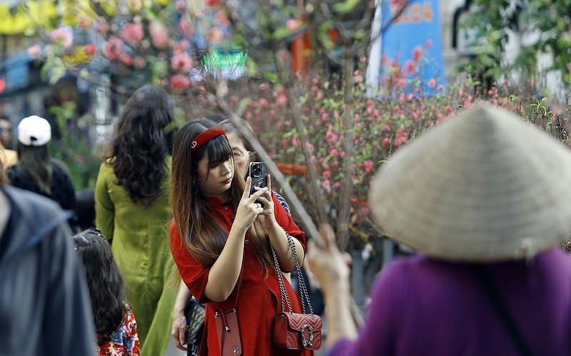 Một cô gái với trang phục áo dài cách tân đang say sưa ghi lại những khoảnh khắc đầy màu sắc của không khí Tết Một cô gái với trang phục áo dài cách tân đang say sưa ghi lại những khoảnh khắc đầy màu sắc của không khí Tết