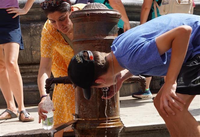 Người dân uống nước để giải nhiệt tại Rome, Italy, ngày 18/7/2023. Ảnh: THX/TTXVN Người dân uống nước để giải nhiệt tại Rome, Italy, ngày 18/7/2023. Ảnh: THX/TTXVN