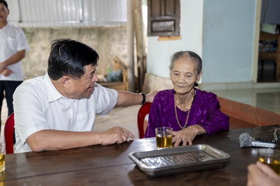 Bộ trưởng Nguyễn Chí Dũng ân cần thăm hỏi, động viên bà Lê Thị Uyên, mẹ liệt sĩ. Ảnh: Trường Sơn