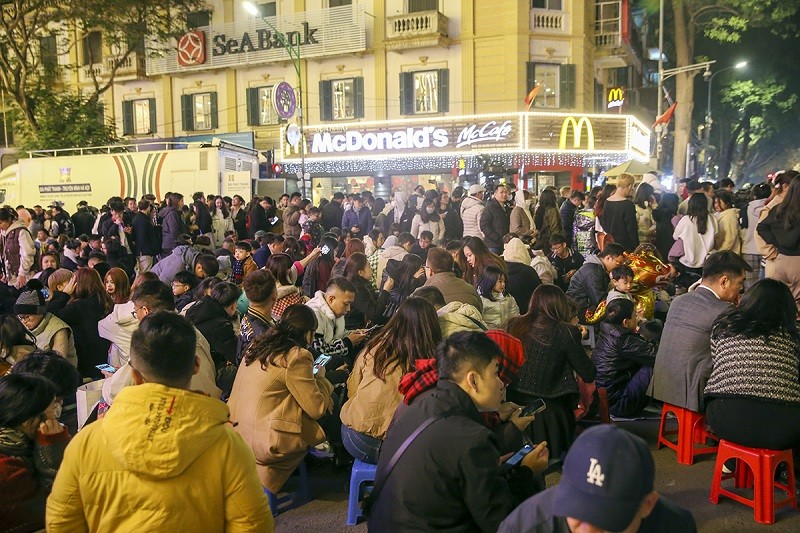Từ 21 giờ đêm 29 tháng Chạp, khu vực trước cửa trung tâm thương mại Tràng Tiền đã có rất đông người xếp hàng, hoặc mua chỗ ngồi xem pháo hoa Từ 21 giờ đêm 29 tháng Chạp, khu vực trước cửa trung tâm thương mại Tràng Tiền đã có rất đông người xếp hàng, hoặc mua chỗ ngồi xem pháo hoa