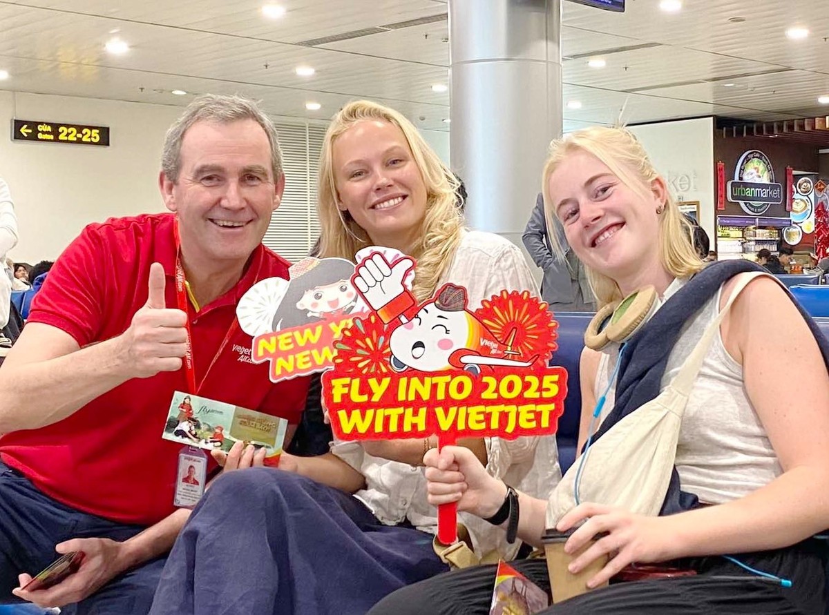 Phó Tổng giám đốc Vietjet Michael Hickey (áo đỏ) chúc mừng năm mới hành khách tại sân bay Tân Sơn Nhất (TP. Hồ Chí Minh)