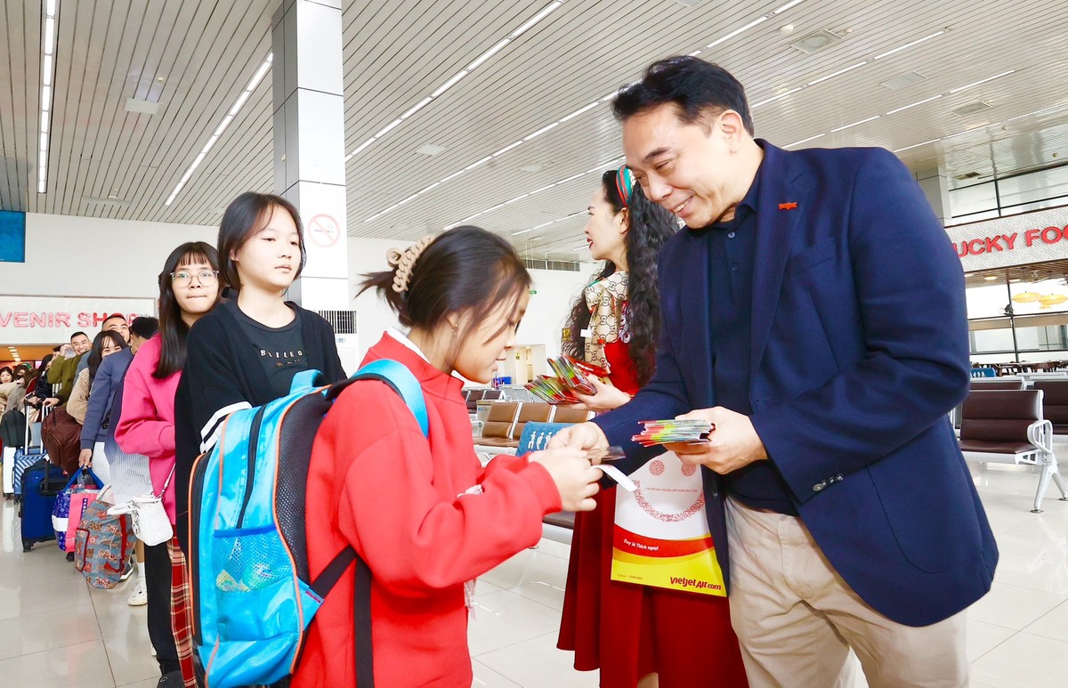 Phó Chủ tịch HĐQT Vietjet Nguyễn Anh Tuấn (áo xanh bên phải) tặng quà lì xì cho các hành khách xuất hành trên chuyến bay Vietjet